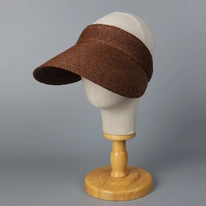 Detail of premium wide-brim raffia sun visor with intricate brown spiral weave texture