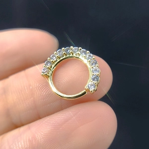 Macro shot of gold micro-pave cubic zirconia nose ring held for detail and sparkle
