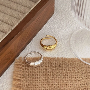 Close-up of gold and silver irregular twist open rings on rustic wood and linen