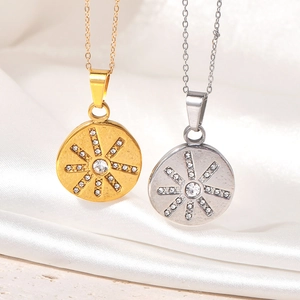 Close-up of gold and silver sunburst necklaces with zircons on white silk fabric