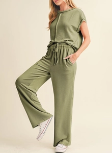 Macro detail of moss green ribbed fabric and drawstring waistband on the pants