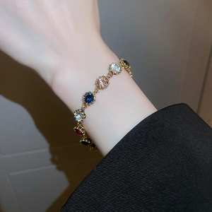Detailed shot of gold plated bracelet with colorful rhinestones on a female wrist