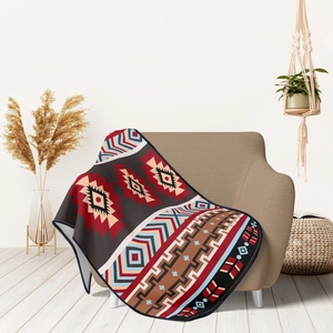 Bohemian geometric flannel blanket in red and blue draped over a cozy modern sofa