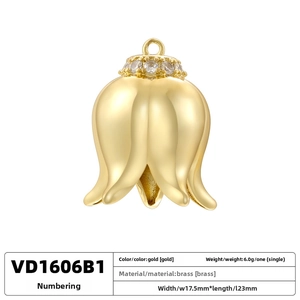 Detailed view of gold lily of the valley pendant with brass texture and zircon inlay