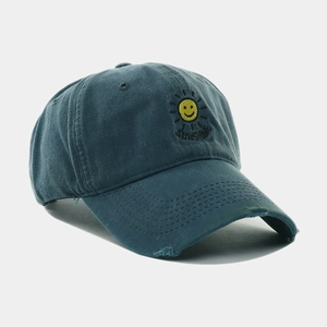 Close-up of yellow sun embroidery and sunshine text on distressed washed baseball cap