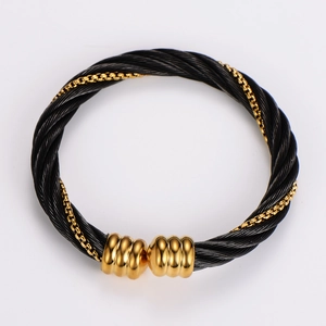 Close-up of twisted black steel cable bracelet with gold chain detail and threaded beads