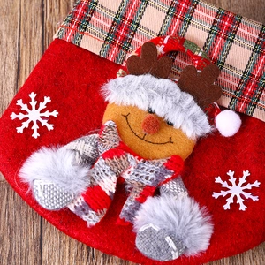 Detail of red Christmas stocking with 3D reindeer mascot and tartan pattern cuff