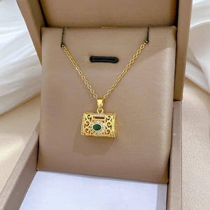 Macro view of vintage gold necklace featuring emerald green stone and filigree pendant