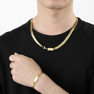 Male model wearing golden stainless steel Cuban link necklace and bracelet set