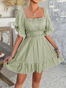 Detail of light green summer dress showing square neckline and ruffled sleeve textures