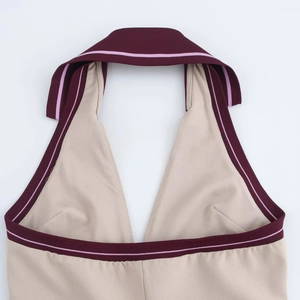 Dettaglio ravvicinato di un abito all'americana stile preppy con scollo a V profondo e bordo bordeaux