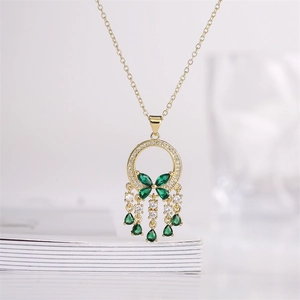 Gold butterfly pendant necklace with green stones and tassels over vintage books