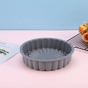 Gray sunflower silicone cake mold with wavy edges shown in a stylish kitchen setting