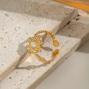 French vintage adjustable gold flower ring with natural opal stone on a marble display