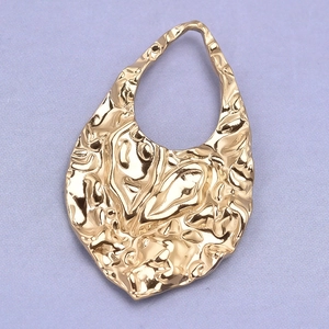 Macro view showing the hammered gold texture of the teardrop shaped 304 steel pendant