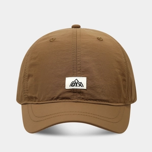 Detail of caramel quick-dry baseball cap with O.Y.X mountain logo patch and fine stitching