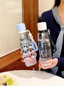 Close-up of portable plastic water cups with colorful hand ropes and cartoon prints