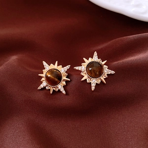 Macro shot of 18K gold plated tiger eye sunburst stud earrings with zircon accents