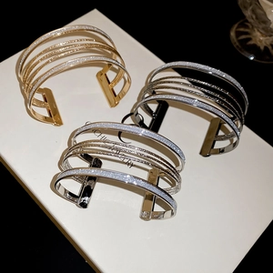 Detail view of multilayer cuff bracelets in gold and silver with frosted glitter finish