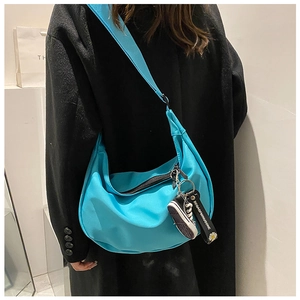 Blue oxford cloth crescent crossbody bag detail with daisy strap and mini sneaker charm