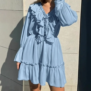 Détail d'une robe bleu clair à col en V avec des volants sur le col et les manches