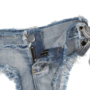 Dettaglio in denim azzurro con bordi sfrangiati, occhielli metallici e lacci laterali