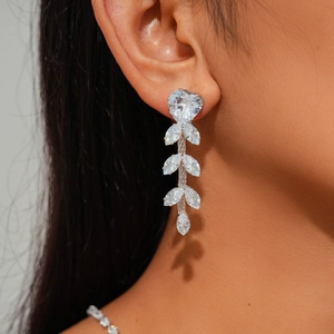 Macro detail of cascading marquise-cut zircon leaf earrings on model for a luxury look