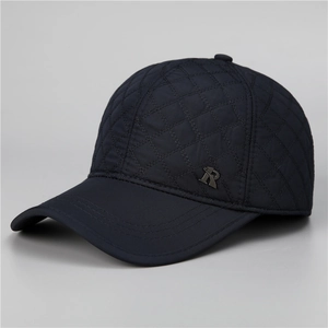 Close-up of navy blue winter baseball cap with diamond quilted pattern and metal logo