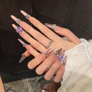 Close-up of pink and purple gradient press-on nails with luxury rhinestones and pearls