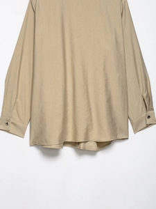 Detailed back hem and buttoned cuff of khaki long sleeve shirt with textured fabric