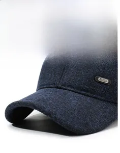 Detail of blue textured baseball cap with curved brim and metallic SPORT emblem tag