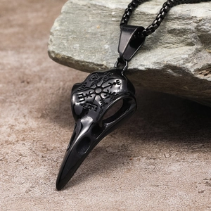 Macro detail of black Viking raven skull necklace with Vegvisir rune compass engraving