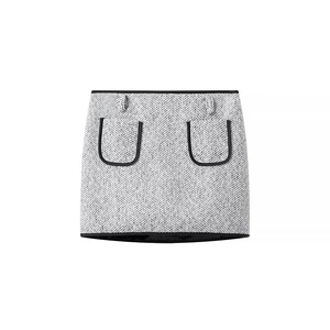 Detail of black and white tweed mini skirt with U-shaped pockets and black trim finish