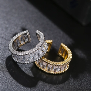 Detail of adjustable gold and silver rings with rectangular cubic zirconia and bead edges