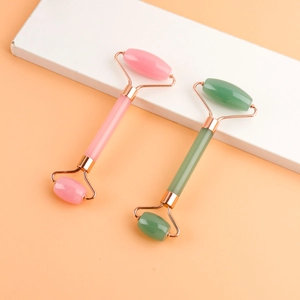 Dual-head natural jade face rollers in pink and green with rose gold metal frames