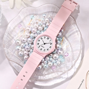 Pink quartz watch with silicone strap on a pearl shell tray for students