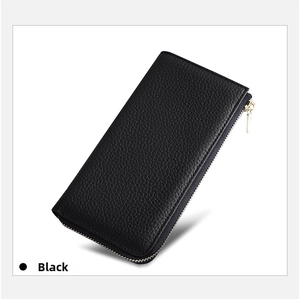 Macro detail of black pebble leather wallet with polished gold zipper closure