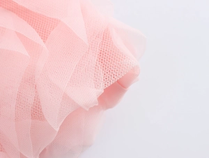 Gros plan sur le tissu en maille rose montrant la texture multicouche et les plis doux