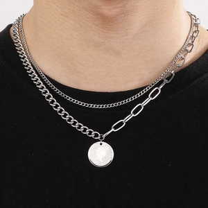 Detailed view of a silver double-layered necklace featuring a queen coin pendant and Cuban chain