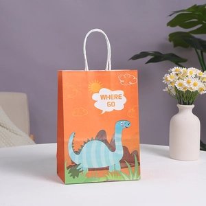 Orange dinosaur kraft paper gift bag with white rope handles on a stylish white table