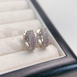 Macro shot of silver hoop earrings with pavé pink pavé zircon stones on jewelry tray