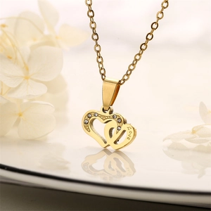 Macro view of gold interlocking heart necklace with crystals and Love engraving detail