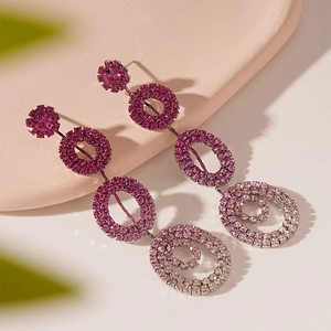 Elegant geometric layered purple crystal drop earrings for women on a decorative plate