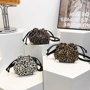Three leopard print drawstring bucket bags in white, yellow, and dark fur textures