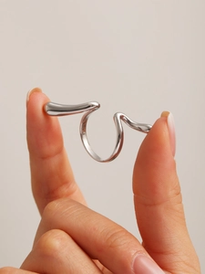 Detail of silver wavy fluid design ring in high-polished stainless steel finish