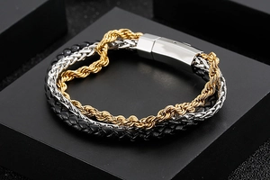 Detail of multi-layer men's bracelet with leather cord and gold twist chain with magnetic clasp
