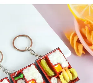 Macro view of miniature Japanese bento box keychain with fried shrimp and rice