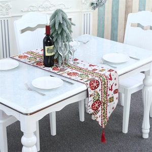 Christmas table runner with reindeer and snowflake patterns and red tassel detail