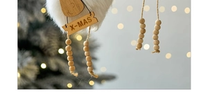 Macro detail of wooden X-MAS deer ornament with white faux fur on Christmas tree branch