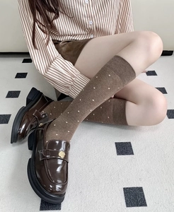 Detail of coffee brown polka dot knee-high socks with vintage academic style knit texture